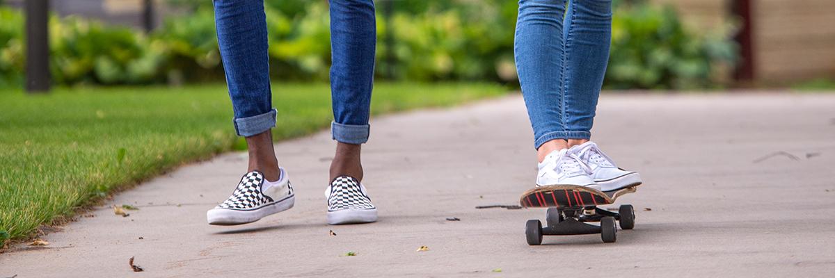 Feet on skate board and feet walking